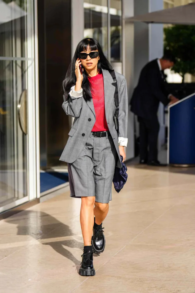 Жіночі аксесуари для літніх образів | Romanova - Businesswoman in gray suit with red top, sunglasses, talking on a mobile while walking outside an office building