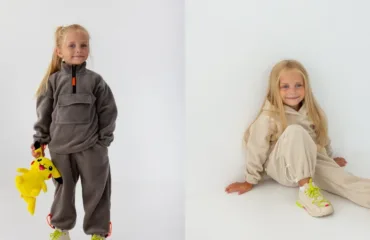 Two young girls in neutral loungewear pose against a white backdrop; one stands holding a yellow Pikachu plush toy, the other sits on the floor.