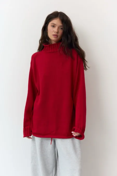 Светр жіночий лимонний бавовняний one size - Woman wearing an oversized red turtleneck sweater and light gray sweatpants, standing against a white wall.