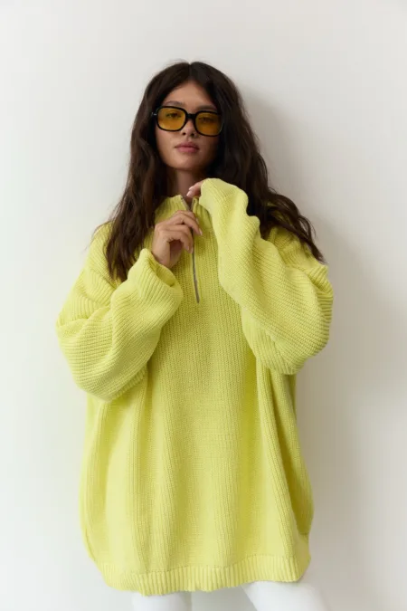 Светр жіночий оливковий бавовняний one size - Person wearing an oversized lemon-yellow knit sweater with a half-zip, black glasses with yellow-tinted lenses, posing against a light backdrop.